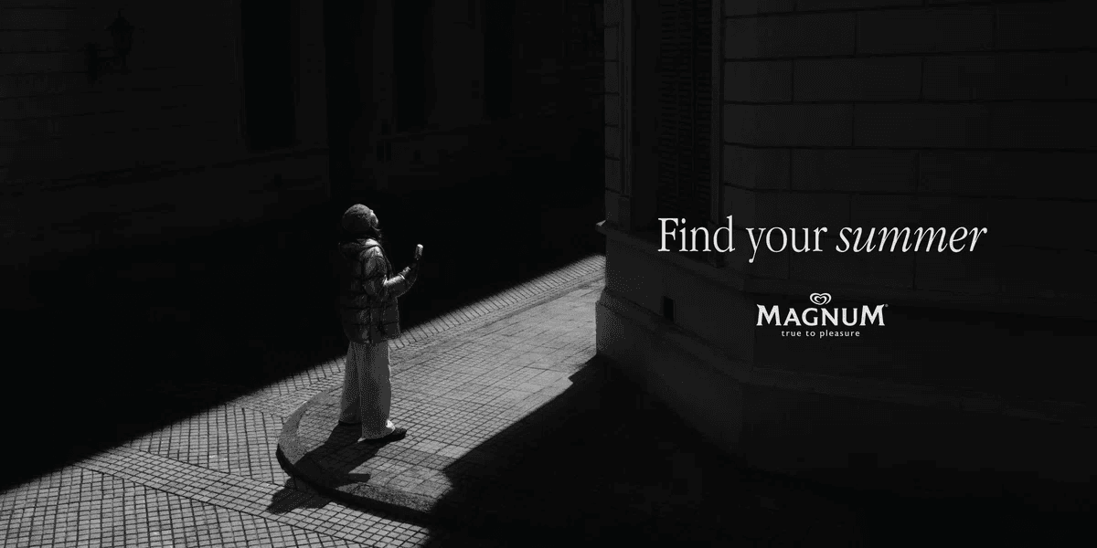 アイスクリームを片手に陽の光を浴びているマグナムの広告